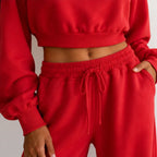 Close-up of women’s red crop sweatshirt and wide-leg pants set with drawstring waistband and pockets
