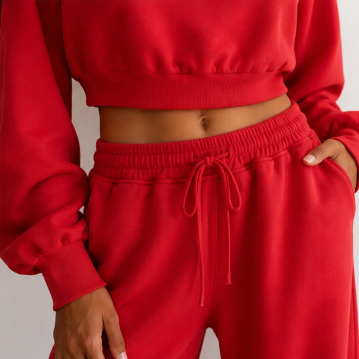 Close-up of women’s red crop sweatshirt and wide-leg pants set with drawstring waistband and pockets