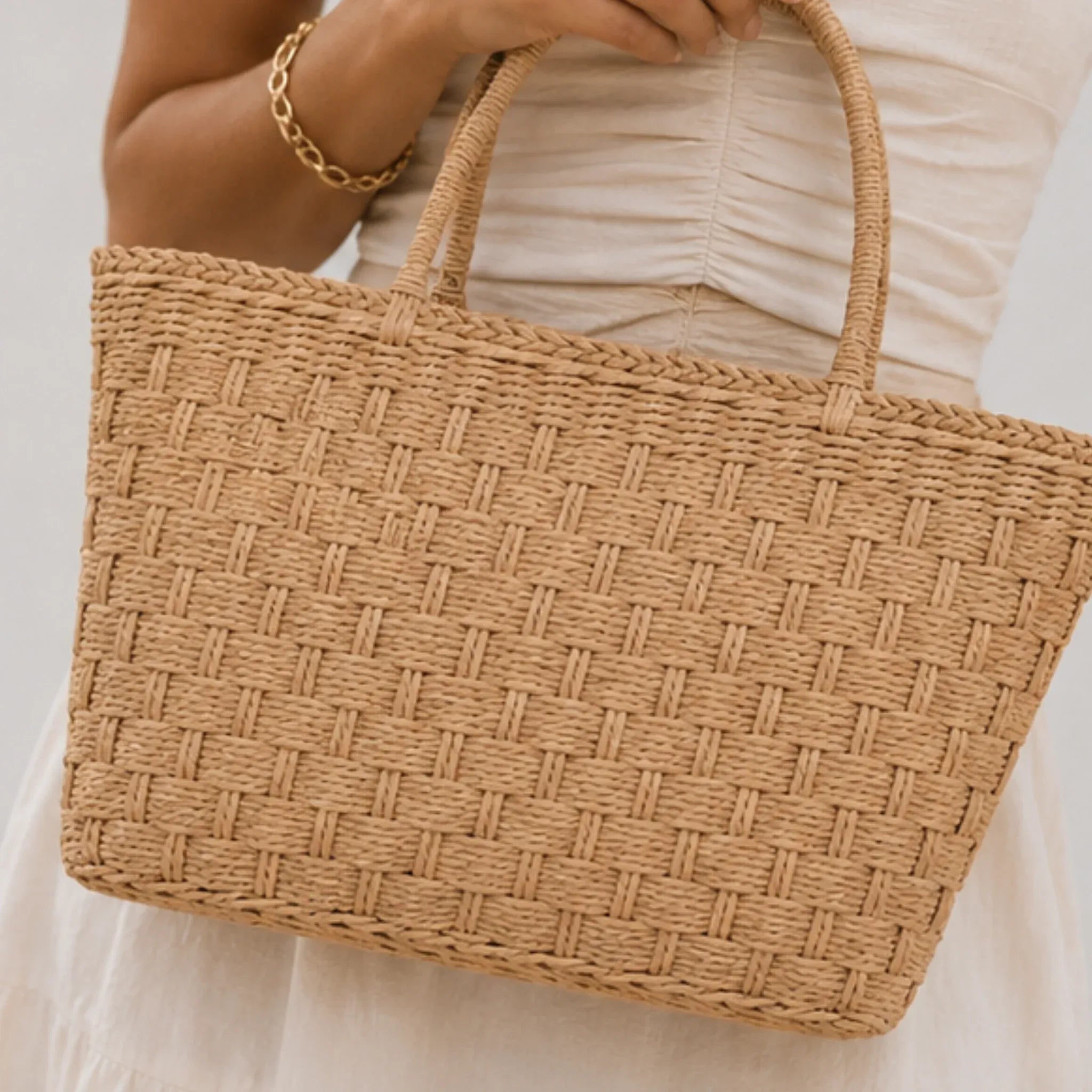 Close-up of a woven straw tote bag showcasing the textured weave and durable double handles.