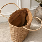 Interior of a woven straw tote bag featuring a zip pocket, slip pockets, and spacious lined compartment.