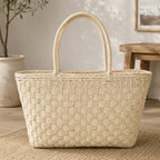 Woven straw tote bag with double handles displayed on a neutral background, perfect for everyday and beach use.