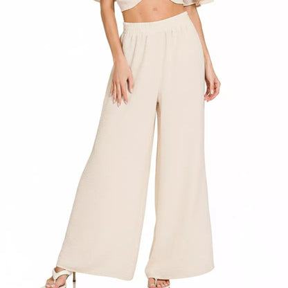 Front view of the sand beige two-piece set showing the elegant twisted top and flowy pants.