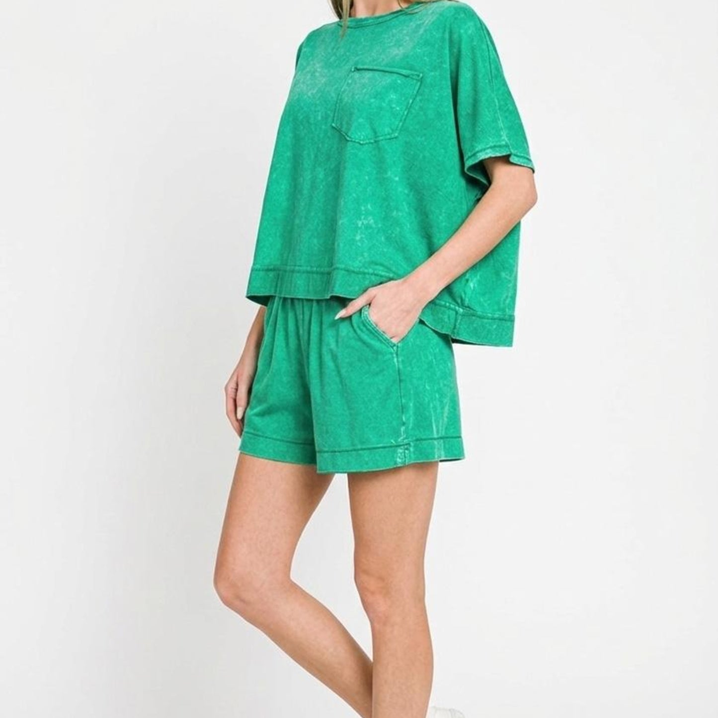 Woman wearing a green outfit with a plain background