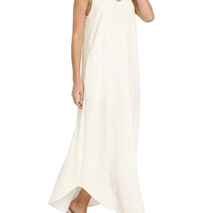 Close-up showing the side slit detail on the flowy ivory woven maxi dress.
